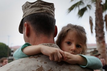 A little girl hangs on to her father